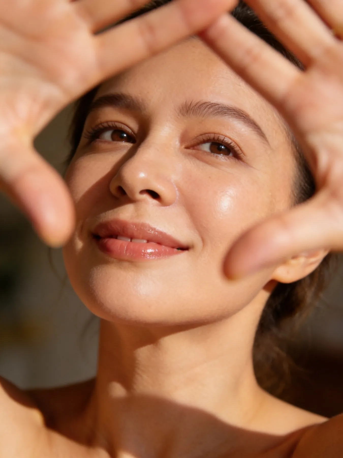 Smiling woman with clear, glowing skin in soft natural light